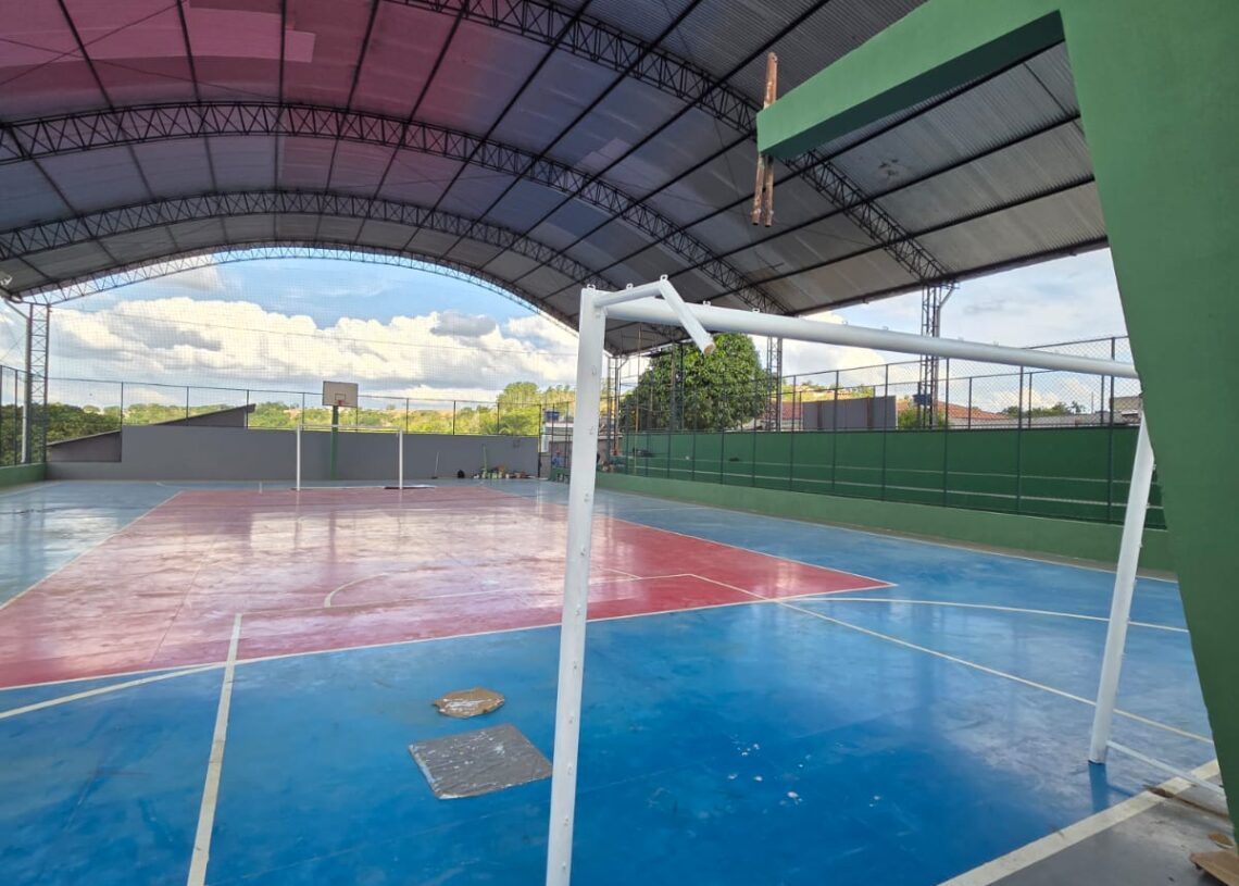 Quadra poliesportiva coberta, com trave de futsal e tabela de basquete